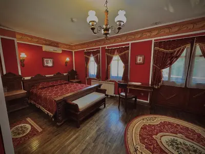 a bedroom with red walls and a bed and a table at Family Hotel at Renaissance Square in Plovdiv