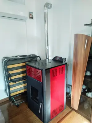 a black and red stove sitting in a room at Holiday Home Veli in Sapareva Banya