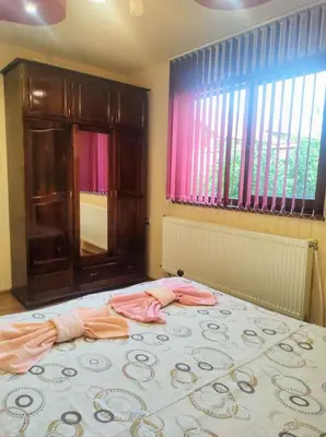 a bedroom with a bed with pink clothes on it at Holiday Home Veli in Sapareva Banya