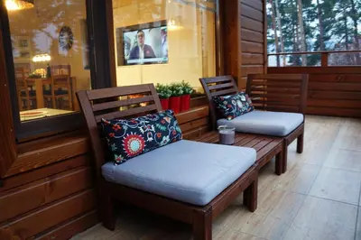two benches sitting on a porch with pillows at Апартамент 