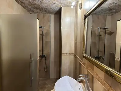 a bathroom with a shower and a sink and a mirror at Family Hotel Bunara in Brestnik