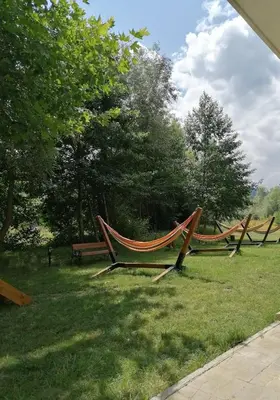 a row of hammocks in a park with trees at Grand Royale Apartment Complex & Spa in Bansko
