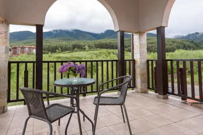 a table and chairs on a balcony with a view at Grand Royale Apartment Complex & Spa in Bansko