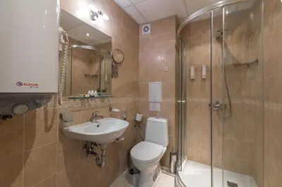 a bathroom with a toilet and a shower and a sink at Grand Royale Apartment Complex & Spa in Bansko