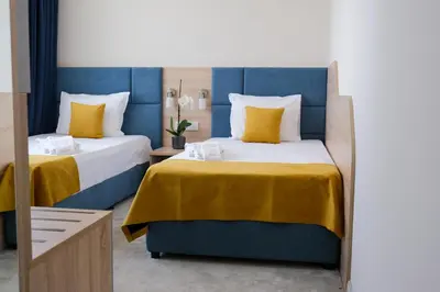 two beds in a room with yellow and blue at SPS Hotel in Plovdiv