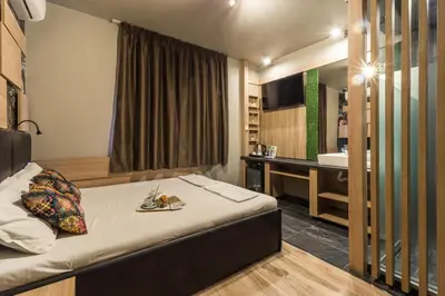 a bedroom with a bed and a bathroom with a sink at Hotel Allur in Plovdiv