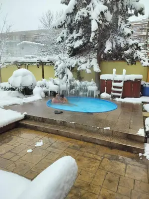 a couple in the pool in the snow at Family Hotel Iv in Velingrad