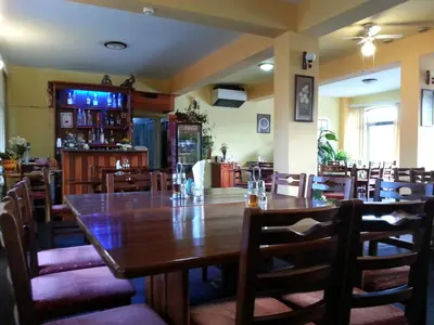 a dining room with a large wooden table and chairs at Family Hotel Iv in Velingrad