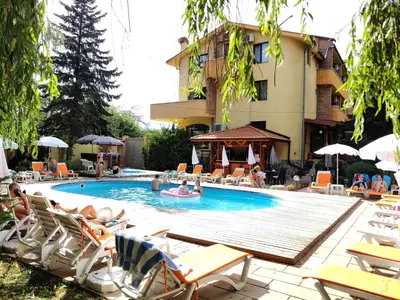 a swimming pool with lounge chairs and a hotel at Family Hotel Iv in Velingrad