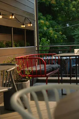 a red bench sitting on top of a patio at Family Hotel Ramira in Kyustendil