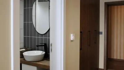 a bathroom with a white sink and a mirror at Family Hotel Ramira in Kyustendil