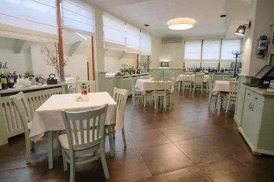a dining room with tables and chairs in a restaurant at Family Hotel Ramira in Kyustendil