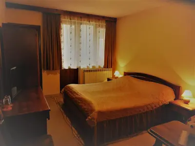 a hotel room with a bed and a window at Boyadjiyski Guest House in Bansko