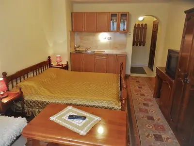 a bedroom with two beds and a table and a tv at Boyadjiyski Guest House in Bansko