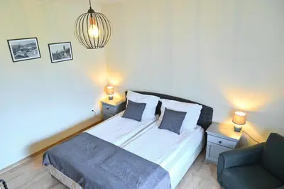 a bedroom with a bed and a chair and two lamps at Klecherova House in Bansko