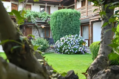 a garden with purple and white flowers in front of a building at Klecherova House in Bansko