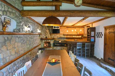 a dining room with a long wooden table and chairs at Klecherova House in Bansko