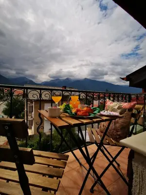 a balcony with a table with food and drinks on it at Zigen House in Bansko