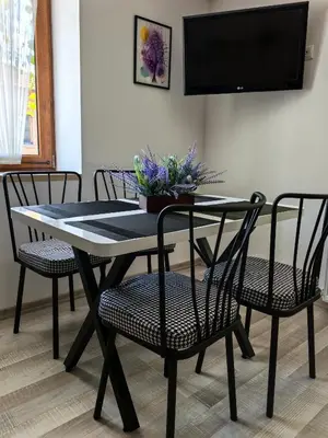 a dining room table with chairs and a tv at Zigen House in Bansko