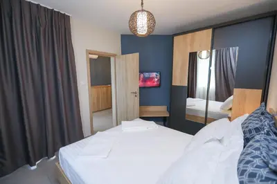 a bedroom with a white bed and a mirror at Artemis Apartments in Sandanski