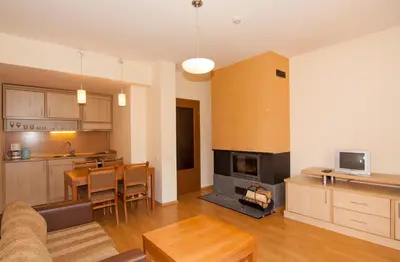 a kitchen and living room with a couch and a table at Апартаменти Малина in Pamporovo