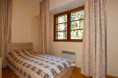a bedroom with a bed and a window at Апартаменти Малина in Pamporovo