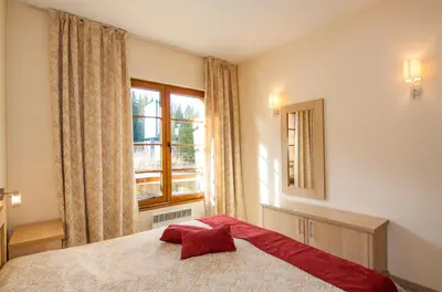 a bedroom with a large bed and a window at Апартаменти Малина in Pamporovo