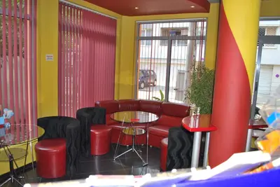 a restaurant with red chairs and tables and yellow walls at Hotel Milenium in Sofia
