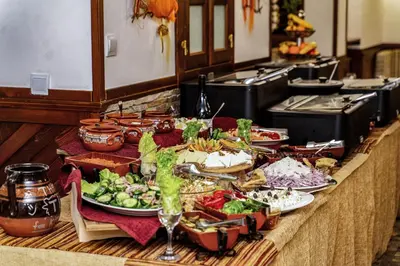 a buffet with plates of food on a table at MPM Family Hotel Merryan in Pamporovo