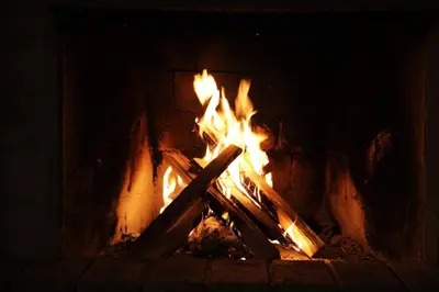 a fire in a brick fireplace with flames at MPM Family Hotel Merryan in Pamporovo