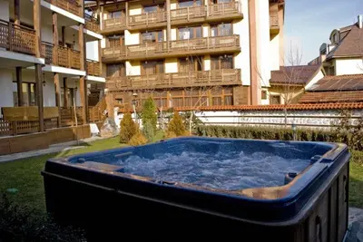 a hot tub in a yard in front of a building at Guest House Chicho Tsane in Bansko
