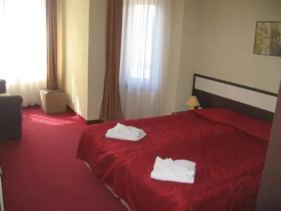 a hotel room with a red bed with towels on it at Apart Hotel Comfort in Bansko