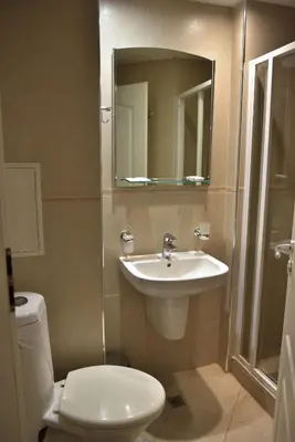 a bathroom with a sink and a toilet and a mirror at Apart Hotel Comfort in Bansko