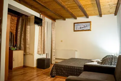 a bedroom with a bed and a couch in a room at Matsurev Han in Bansko