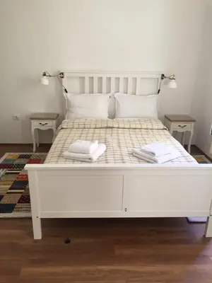 a white bed with two pillows on it at Студия Давидов 