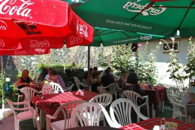 a group of people sitting at tables under a cocacola umbrella at Sky Rooms in Sofia