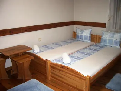 a bedroom with two beds and a table at Sky Rooms in Sofia