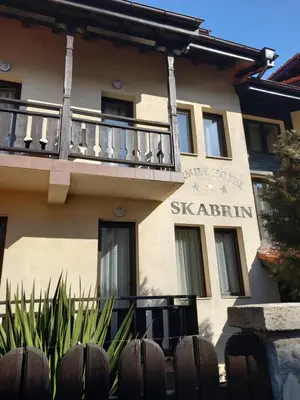 a building with a balcony in front of it at Guest house Skabrin in Bansko