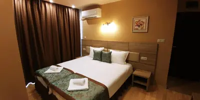 a hotel room with a bed with two towels on it at Garden Guest House in Sandanski
