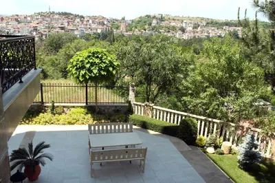 a bench on a patio with a view of a city at Garden Guest House in Sandanski