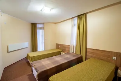 a hotel room with two beds and a window at Ski Chalets at Pamporovo - an affordable village holiday for families or groups in Pamporovo