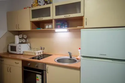 a small kitchen with a sink and a refrigerator at Ski Chalets at Pamporovo - an affordable village holiday for families or groups in Pamporovo