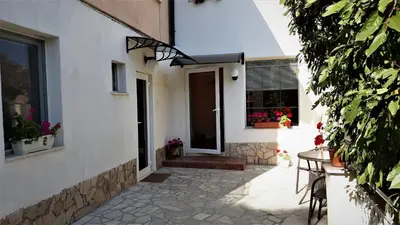 a door to a house with a table and flowers at Andro Apartments in Sofia