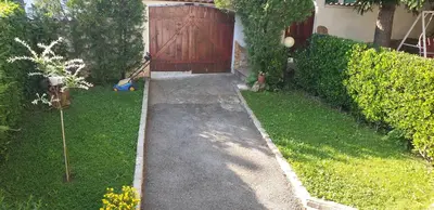 a garden path leading to a house with a wooden door at Andro Apartments in Sofia