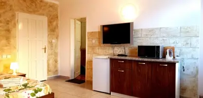 a room with a refrigerator and a tv on the wall at Andro Apartments in Sofia