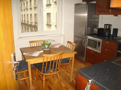 a kitchen with a table and chairs and a kitchen with a refrigerator at Bulhotel Pritzker Apartment in Sofia