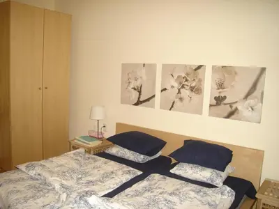 a bedroom with two beds and pictures on the wall at Bulhotel Pritzker Apartment in Sofia
