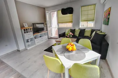 a living room with a white table and yellow chairs at ApArt apartments in Plovdiv