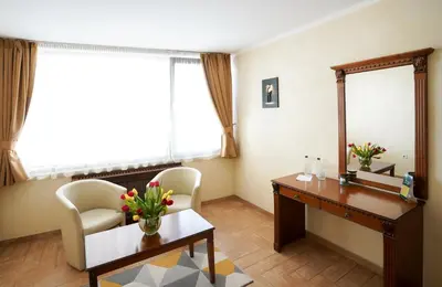 a room with a desk and chairs and a mirror at Central West Hotel in Sofia