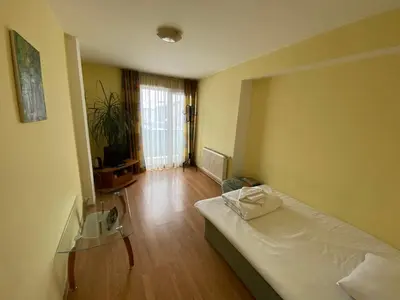 a hotel room with a bed and a room with a window at Family House Oreha in Bansko